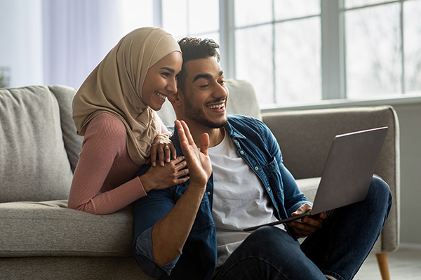 Happy Asian couple speaking with a Foresters Financial Adviser on video call