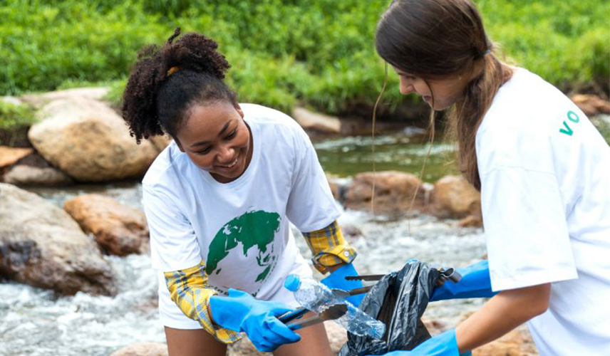 2 young women cleaning up garbage