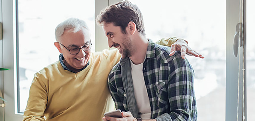 Elderly father and son reading the Foresters guide to ISAs