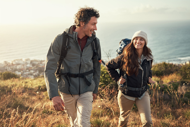 Couple who are saving for later in life with a Lifetime ISA hiking at sunset