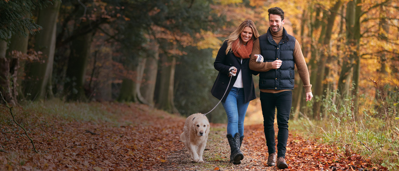 Couple with a Stocks and Shares ISA walking their dog 