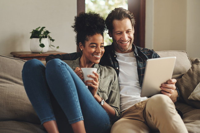 Couple on tablet reading about a Stocks and Shares ISA