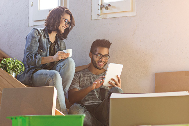 Couple sitting on the stairs looking at their Lifetime ISA on MyPlans 