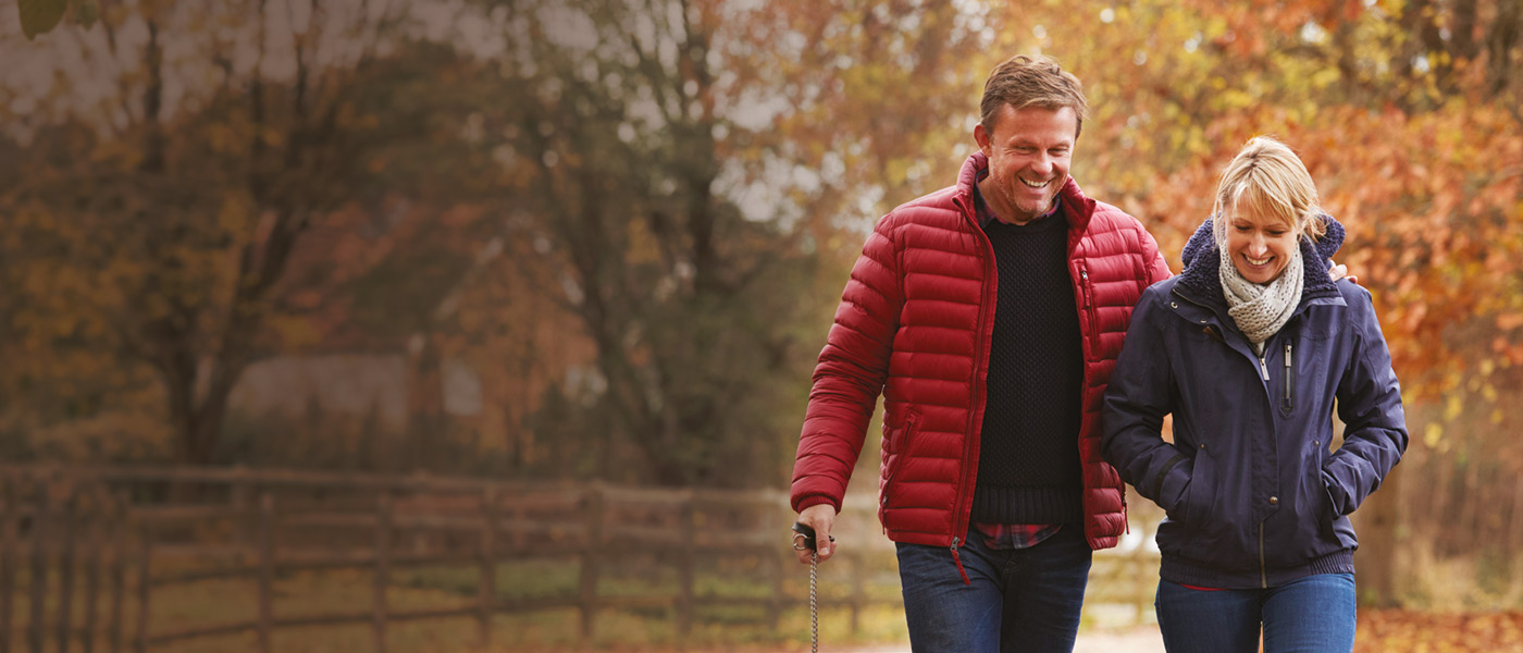 Happy couple with a joint Savings & Investment Plan on a walk in the park