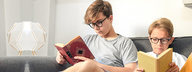 Boys reading books learning the difference between a Child Trust Fund and Junior ISA