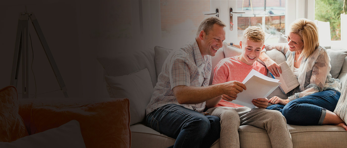 Teenager with his parents learning about his Foresters savings Plan at 18 on their sofa