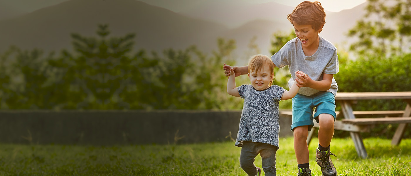 Brother and sister with Foresters child savings Plans playing in the garden