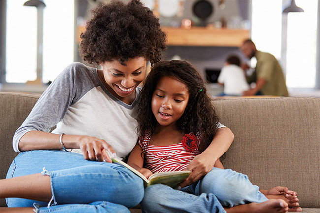 Mother reading to her daughter who transferred her child savings to Foresters