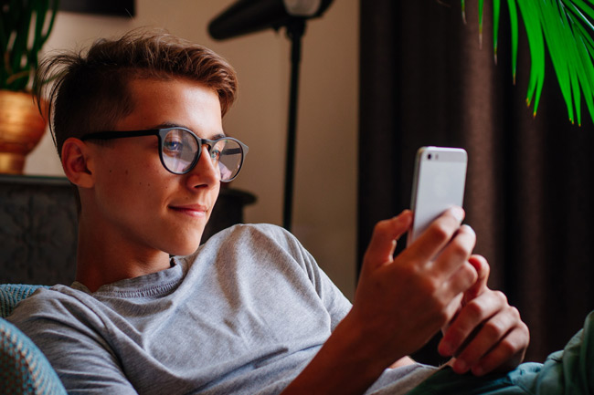 Teenage boy on phone looking to see which fund his CTF invests in