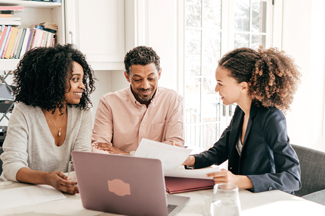 Father and daughter sitting on a grey sofa using an iPad to activate their online Child Trust Fund account