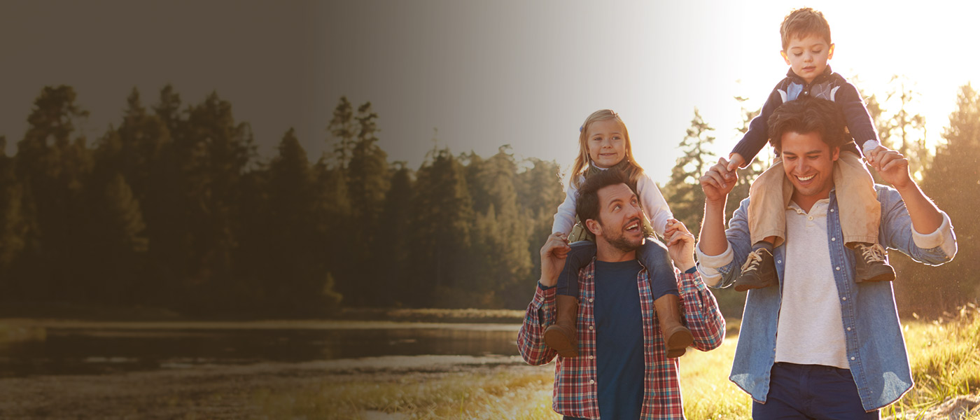 Happy couple with kids by a lake knowing they have Insurance with Foresters