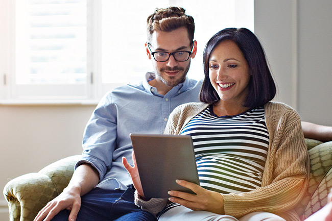 Couple reading about Foresters Insurance products online