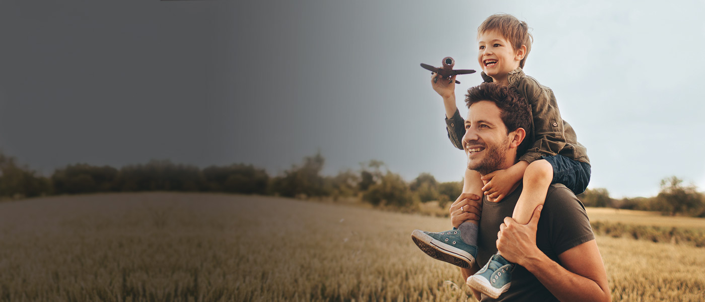 Father and son playing in a field with mortgage protection