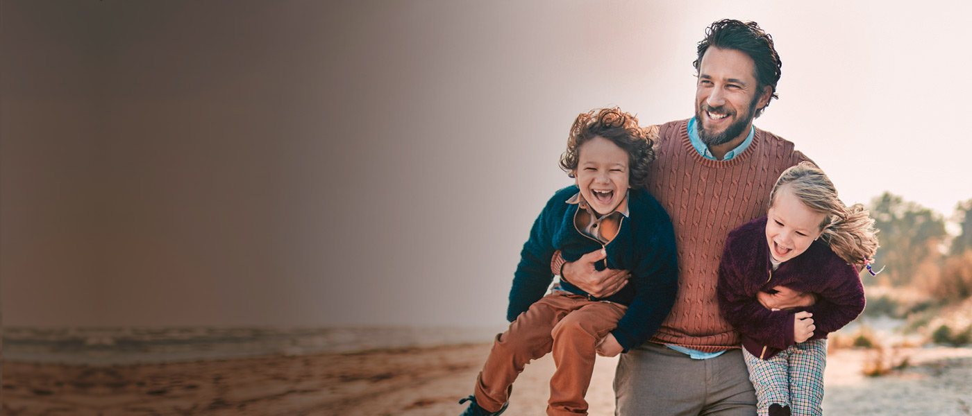 Dad with children at the beach thinking about personal insurance options