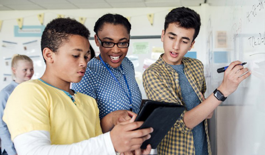 Des étudiants et des enseignant qui écrivent sur un tableau blanc